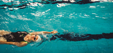 Woman swimming with swimming hat in swimming poolの写真素材