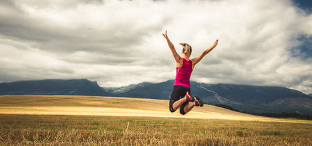 Young woman jumping in the mountainsの写真素材