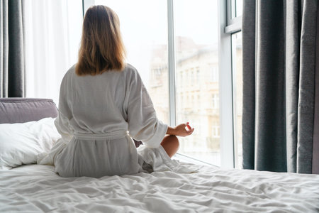 Woman in white bathrobe lying on sofa and relaxing at hotel room.の写真素材