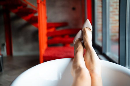Close up of female legs in high heels in a bathtub.の写真素材