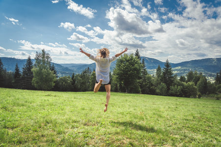 Legs of a young woman sitting on the grass in the parkの写真素材