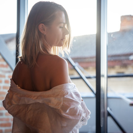 Woman relax and standing near window. window reflectionの写真素材