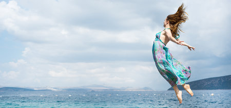 Young woman jumping on the beachの写真素材