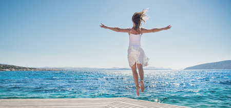 Young woman jumping on the beachの写真素材