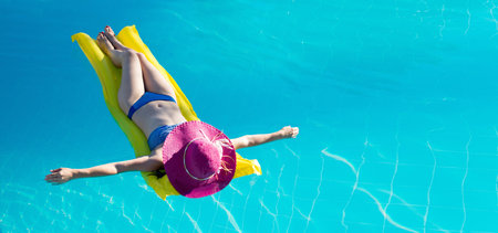 Young woman enjoying a swimming poolの写真素材