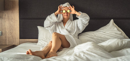 young woman getting eye nature treatment by cucumber at luxury spa resort. Wellness and healing concept.の写真素材