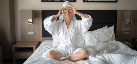 young woman getting eye nature treatment by cucumber at luxury spa resort. Wellness and healing concept.の写真素材