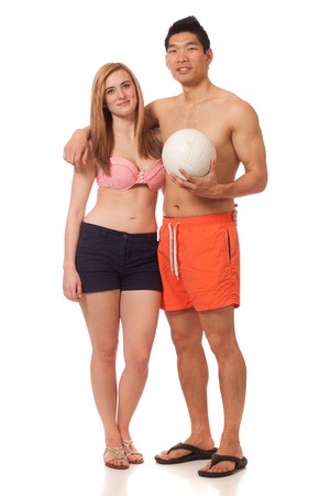 Young couple in swimwear with volleyball. Studio shot over white.の写真素材