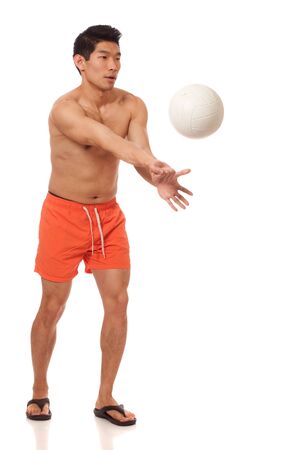 Young man playing volleyball. Studio shot over white.の写真素材