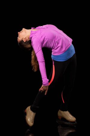 Young adult figure skater. Studio shot over black.の写真素材