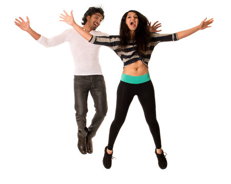 Young couple jumping with excitement. Studio shot over white.の写真素材