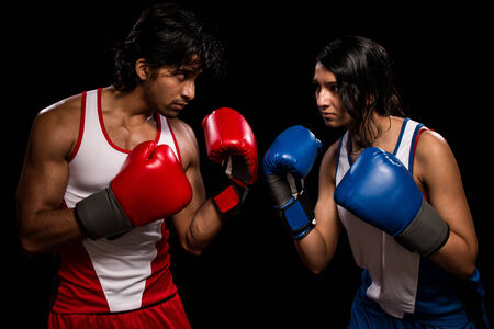 Male and female boxers "Battle of the sexes". Studio shot over black.の写真素材