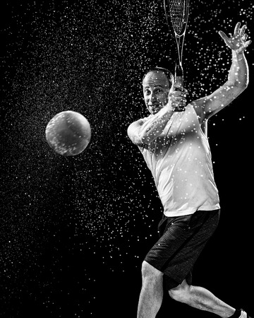 Tennis action shot. Forehand. Studio shot over black.の写真素材