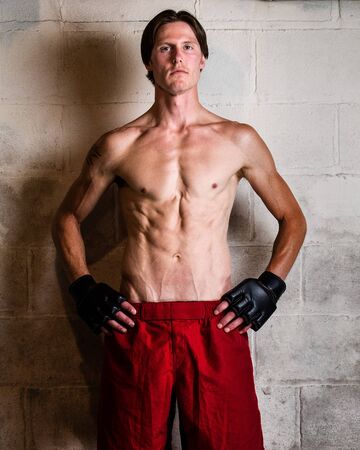 Young adult martial artist in front of a concrete block wall.の写真素材