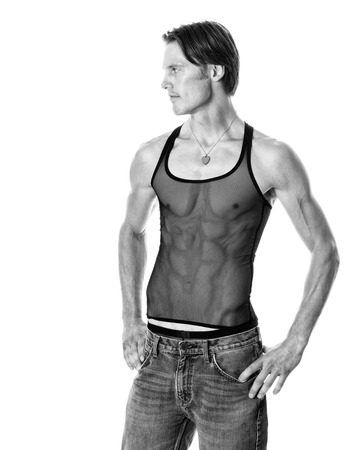 Man in mesh tank top and jeans. Studio shot over white. Black and white.の写真素材