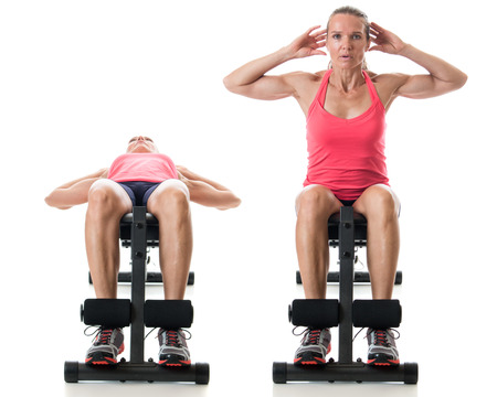 Bench sit-up exercise. Studio shot over white.の写真素材