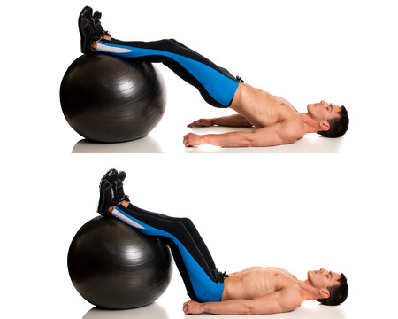 Man exercising with a stability ball. Studio shot over white.の写真素材