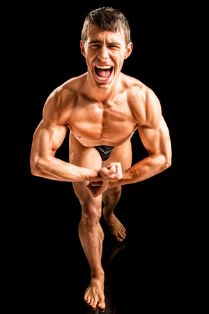 Bodybuilder posing. Studio shot on black.の写真素材