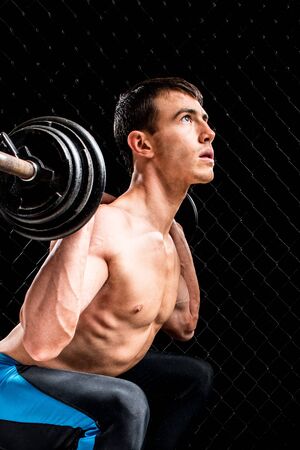 Barbell Squat Exercise. Studio shot over black.の写真素材
