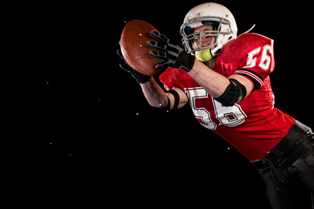 American football player. Studio shot over black.