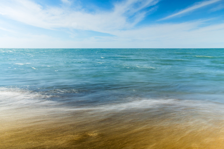 Sunny beach with small waves. Long exposure.の写真素材