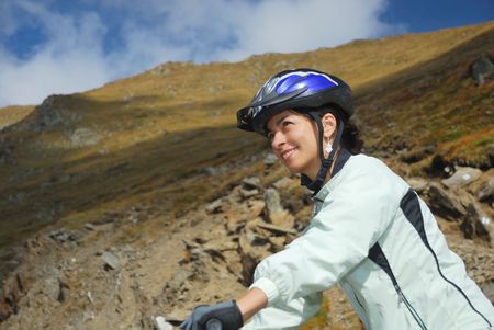 young happy woman riding safety a mountain bikeの写真素材
