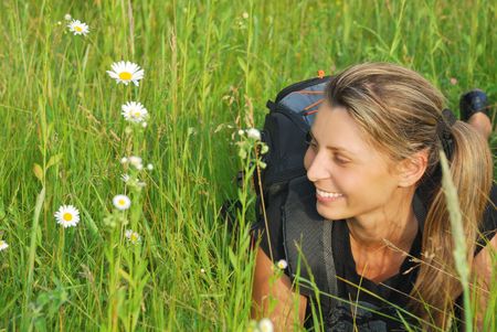 Beautiful young woman resting and smiling in green grass 