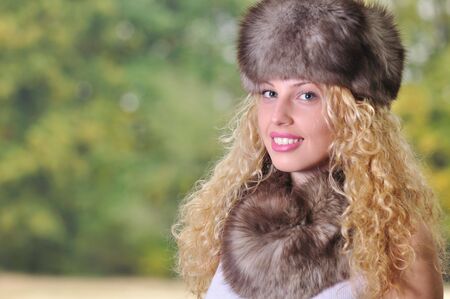 beautiful Caucasian girl wearing fur cap and collar with green copy spaceの写真素材