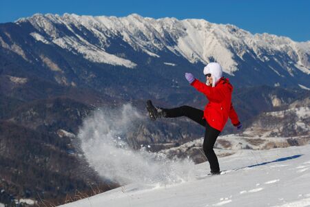 Happy girl shooting the snow in a fine day in Mountainsの写真素材