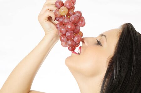 beautiful young woman with perfect natural skin, eating fresh ripe grapesの写真素材