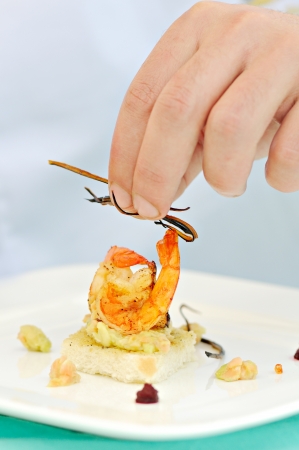 human hand setting up a delicious toasted shrimp mealの写真素材
