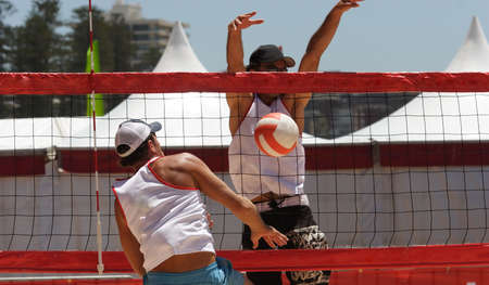 Beach volleyball players at the netの写真素材