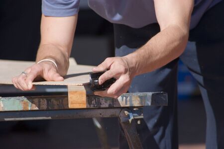 Carpenter using a plane on woodの写真素材