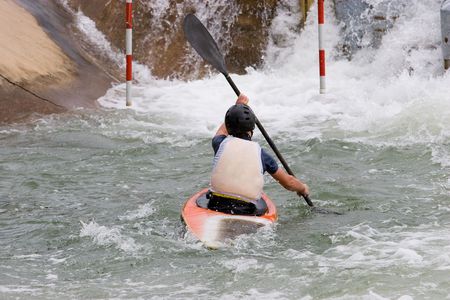 A canoeist paddling through fast running white waterの写真素材