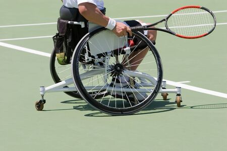 A wheelchair bound athlete on the tennis courtの写真素材