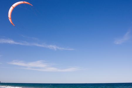 A beach scene with a surf kite in the airの写真素材