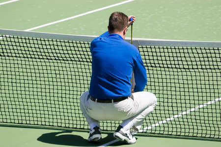 Measuring the height of the netの写真素材