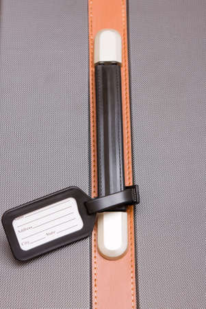 A black luggage tag on a handle on a bagの写真素材