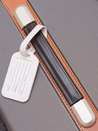 A white luggage tag on a handle on a bagの写真素材