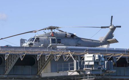 A navy helicopterr on the deck of an aircraft carrierの写真素材