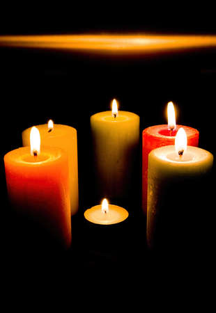A set of colored candles in the darkの写真素材