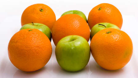 Apples and an oranges against a white backgroundの写真素材