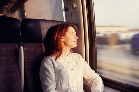 Traveling Comfort -Young woman sleeping feeling relaxed traveling  in the train.の写真素材