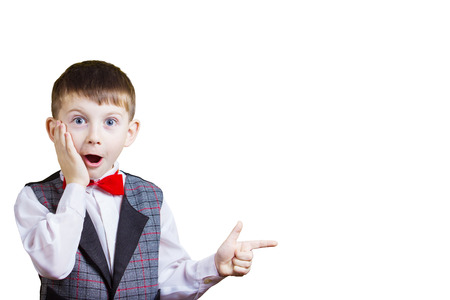 Surprised Pointing little boy isolated over yellow background.の写真素材