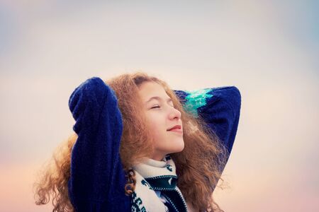 Enjoyment -happy, smiling little girl enjoying a new breath of fresh air, face raised in sky...