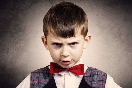 Stubborn, sad, upset little boy, child isolated over grey background.Facial expressionの写真素材