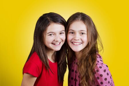 Friendship.Happy smiling two little girls, schoolgirls.の写真素材