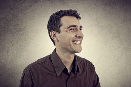 Smiling excited young man isolated on grey background.Closeup shot of Happy smiling student in shirt over grey background.の写真素材