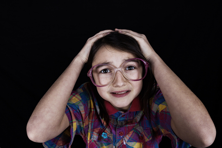 Stressed little girl having problems.Portrait of little girl suffering from headache and holding hands on her head.の写真素材