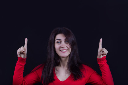 Pointing up Happy excited energetic woman .Portrait of cheering beautiful young women.Facial...
